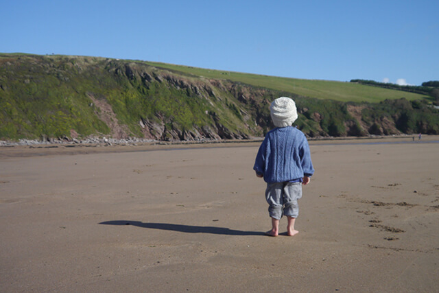 Little boy on beach in sunhat