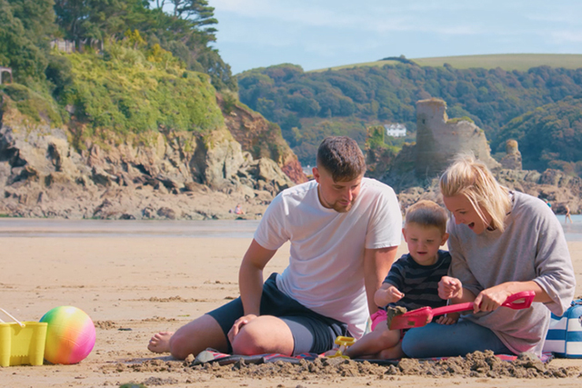 Family building sandcastles on the beach