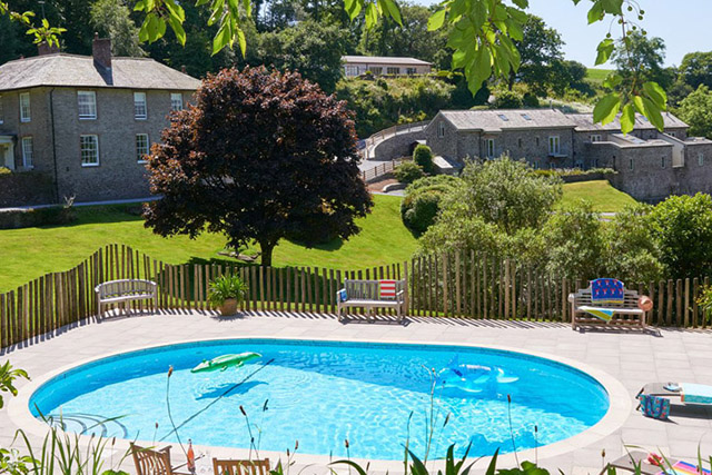 holiday let facilities - swimming pool with gardens and grounds and holiday lets in background.