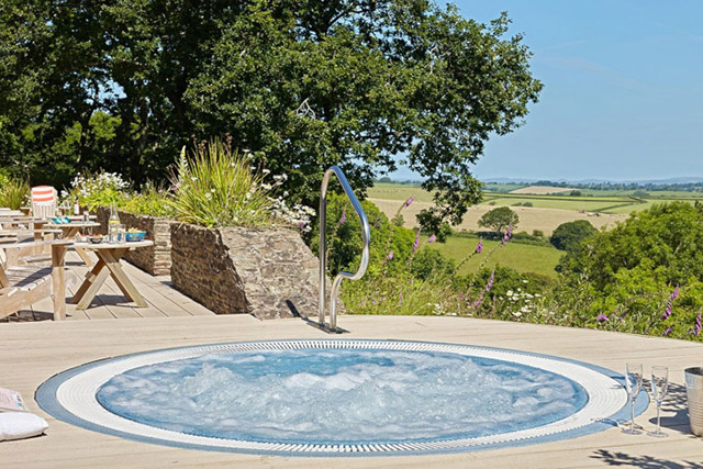 hot tub sunk into patio overlooking the devon countryside.