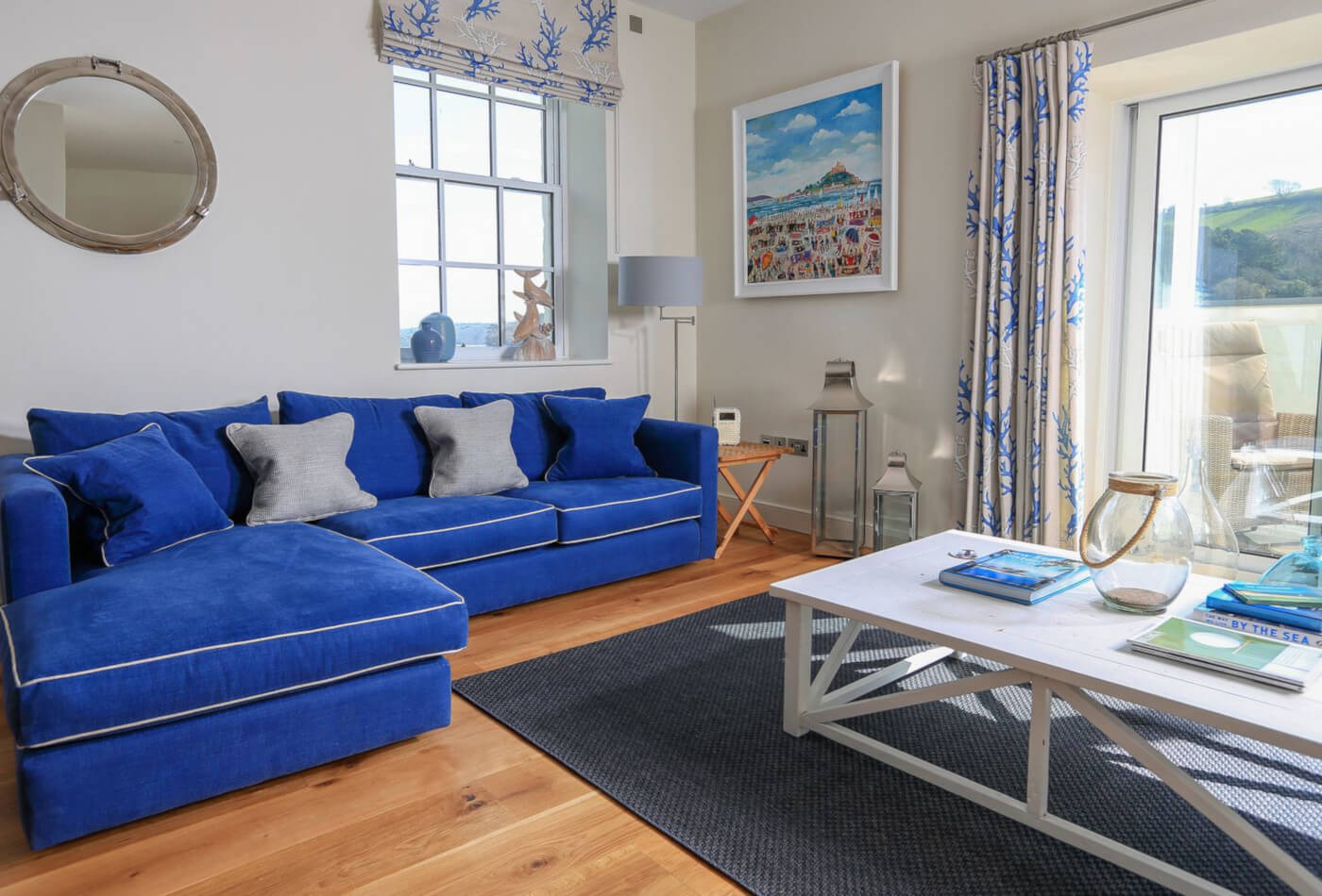 Guest information pack on table in lounge with blue sofas and patio doors.