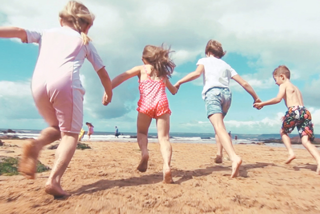 children running on beach in summer