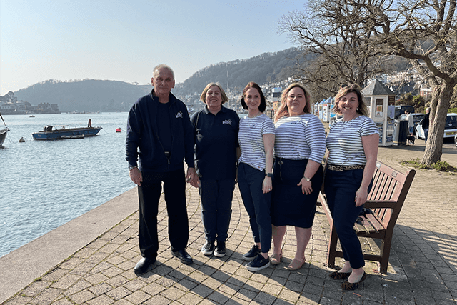 Dartmouth Coast & Country Cottages team posing on Dartmouth harbour.
